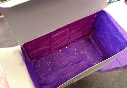 adding purple tissue paper inside the box