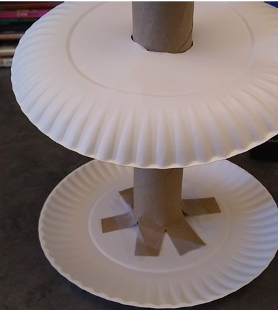 Slide the plate with the cut out of the circle down the paper tube to complete ring toss base.