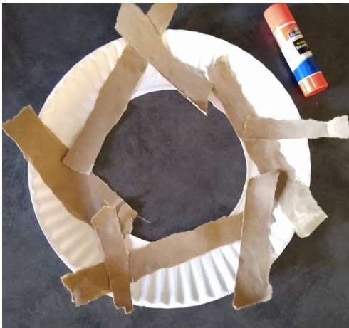 Glue the strips onto the paper plate